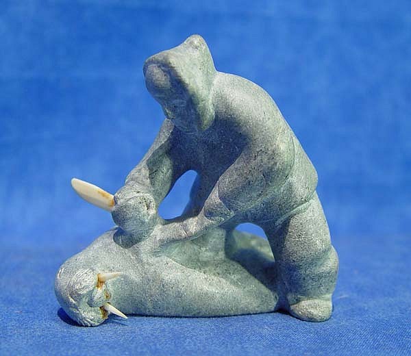 10 - Pacific Northwest, Eskimo  carving: man butchering  walrus, with ivory knife tusks